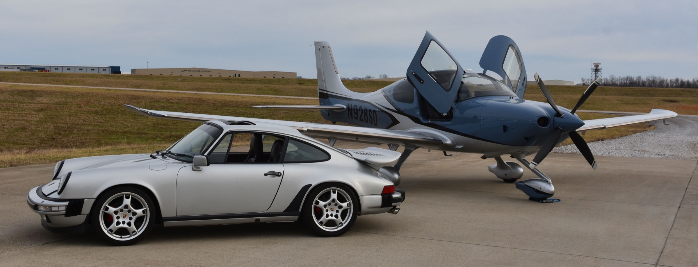 A Cirrus and a sports car on the ramp